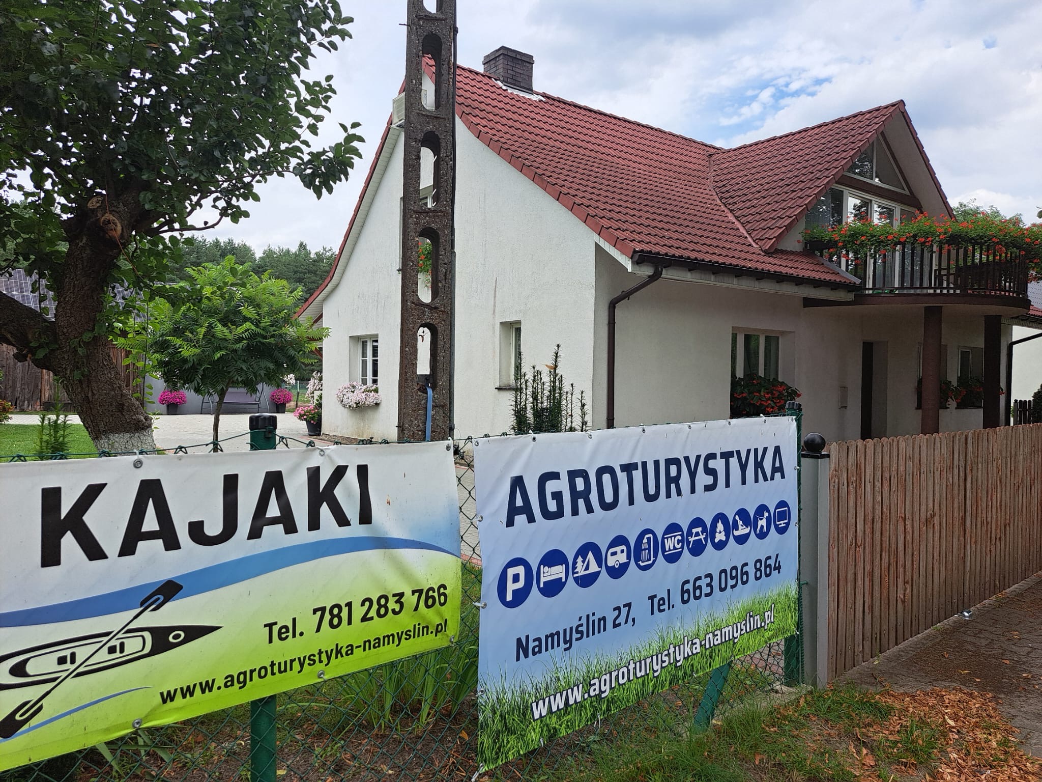 Szyld Kajaki Agroturystyka Namyślin 27 przed budynkiem